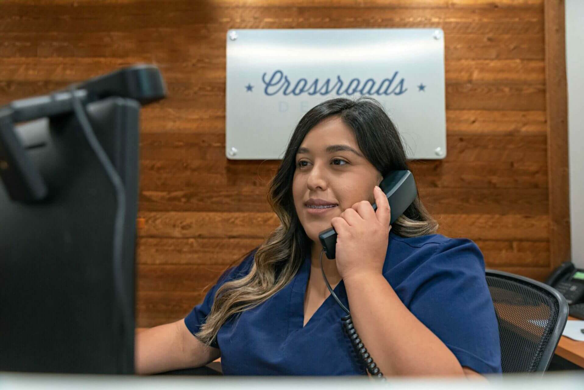 Crossroads Front Desk answering phone in Luling